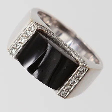 Ring med svart sten samt briljantslipade diamanter 30 x 0,01ct, stl: 18, bredd 5-9mm, svart sten sitter något sned, behov av omrodiering, viktguld 18K.  Vikt: 10,6 g