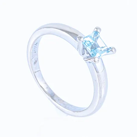 Ring "Happy" i 18K vitguld med en akvamarin 5 x 5 mm. Den är i storlek 17, är 2 - 6,5 mm bred och väger 4,2g. Stämplad GL (Golden Lady), 750. 