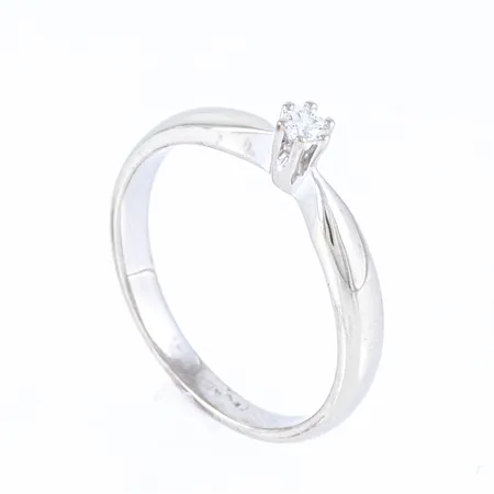 Stjärnring Bellatrix i 18K vitguld med en briljant 0,10ct (TW/P1). Den är i storlek 19¼, är 2,5 - 3,5 mm bred och väger 4,1g. Stenstorlek 0,10ct ingraverad. Stämplad HS (Hans Strömdahl, Stockholm), Stjärnringens stjärna, 18K & kattfot. Nypris ca. 14.600 kr.