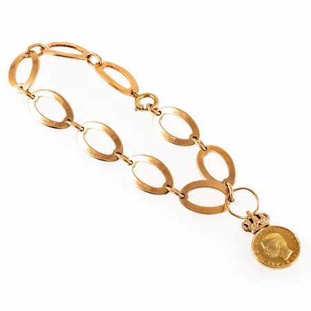 Armband i 18K guld. Det är 19,5 cm långt, 11,3 mm brett och väger 19,2g. Springring. Monogramgravyr under en länk. Medalj stämplad "FÖR LÅNGVARIG UPPSKATTAD ARBETSINSATS". Tillverkat 1975 av Atelier Borgila. 