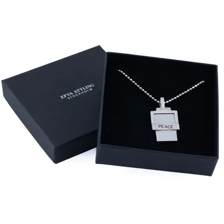 Hänge, Efva Attling "Imagine Peace" i silver (925/1000) med kedja fasetterad kullänk 45 cm. Hängets mått 35 x 19,5 mm. Originalask medföljer. Vikt: 17,2g. Nypris 2000 kr.