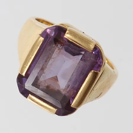 Ring med lila sten, stl 13¾, bredd ca 2,2-12,5mm, repig, 18K Vikt: 6,5 g