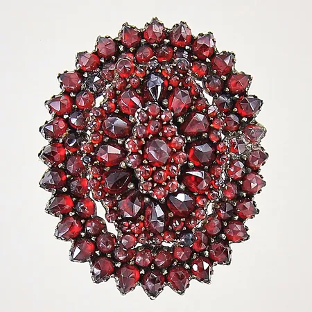 Brosch med granater, 38x31mm, nål samt fattning i gulmetall, skev, lagningar, metall