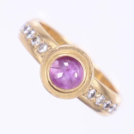 Ring med lila sten, troligen cabochonslipad rubin, samt diamanter totalt 10xca 0,02ct, stl 18, bredd 5-8mm, 18K  Vikt: 5,6 g