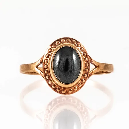 Ring i 18K guld med en hematit 7 x 5 mm. Den är i storlek 17, är 1,5 - 11 mm bred och väger 1,3g. Stämplad SGP, 18K, kattfot.