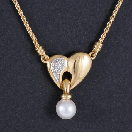 Collier i 18K guld med integrerat hänge: Hjärta med 5 x c:a 0,01ct 8/8 slipade diamanter och en odlad vit pärla Ø 8 mm. Det är 45 cm långt, kedjans bredd 1,7 mm. Hängets mått 17,5 x 25,5 mm. Vikt: 11,9g. Karbinhake. 