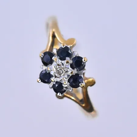 Ring med mörkblåa stenar och en vit sten, stl 17¼, bredd skena 2 mm, skev skena, 18K. Vikt: 1,9 g