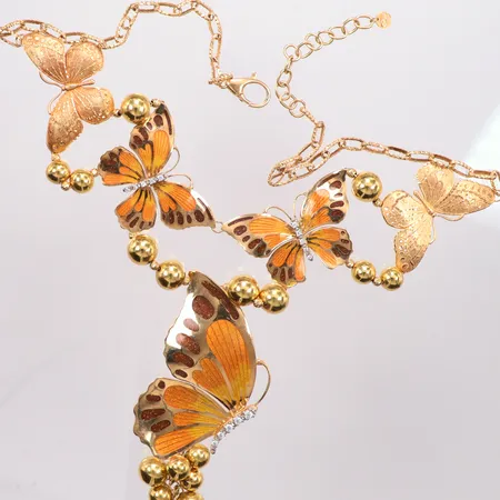 Set med fjärilar emalj, collier 51cm, armband defekt 18cm, ett par örhängen 2,5cm, ring Ø18¼, 18k Vikt: 52,6 g