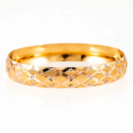 Armring i 21K guld med fasetterat rutmönster. Innermått 20,5 cm, Ø 65,5 mm, bredd 12 mm. Vikt: 14,9g.