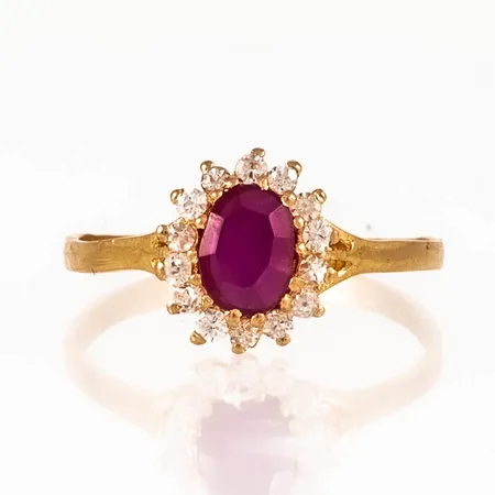 Carmoséring i 21K guld med en syntetisk rubin c:a 6,5 x 4,5 mm och 14 vita stenar. Den är i storlek 18, är 1,7 - 10 mm bred och väger 2,4g.