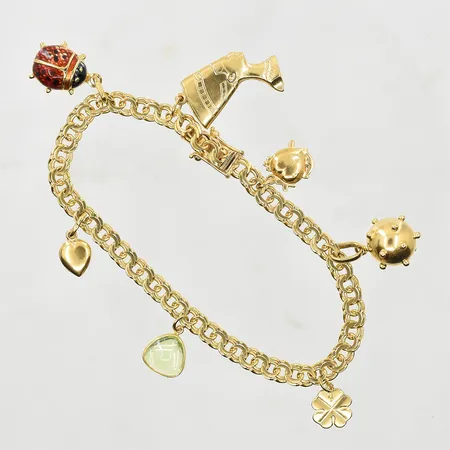 Armband Bismarck med 7 berlocker, längd 18 cm, bredd 5 mm, 18K. Vikt: 17,7 g