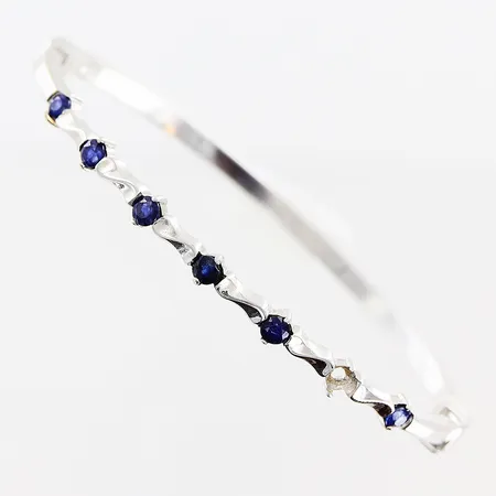 Armring, blå stenar, 66x48mm, bredd 3-4mm, vitguld, 1 sten saknas, 18K.  Vikt: 8,3 g