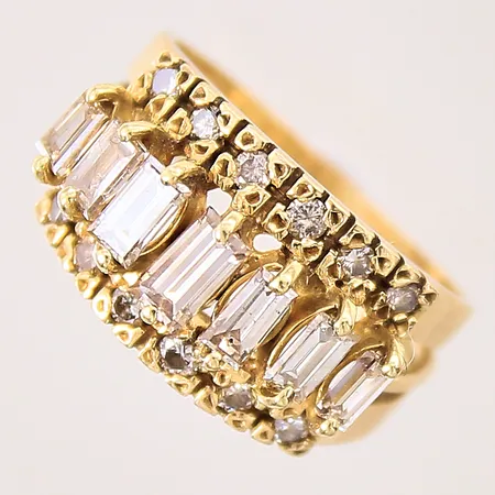 Ring med baugette/trapetsslipade diamanter, 7xca 0,10-0,16ct, 12xca 0,02ct, stl: 17½, bredd: 1,9mm, smärre buckla på skena, ostämplad 18K Vikt: 6,7 g