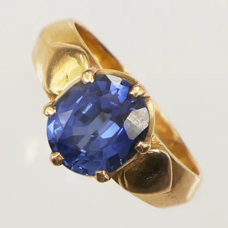 Ring med blå sten, möjligen syntetisk krysoberyll, stl 17½, bredd 10,6mm, ostämplad, 18K Vikt: 6,4 g
