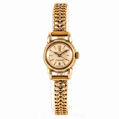 Damur Omega Ladymatic, guld på stål med urband Fiskbenslänk i 18K guld. Boett Ø 19,5 mm, manuell, original plexiglas (repigt), bandets bredd 7,5 mm, total längd 18 cm. Bruttovikt: 24,5g (Vikt enbart band c:a 12,0g)