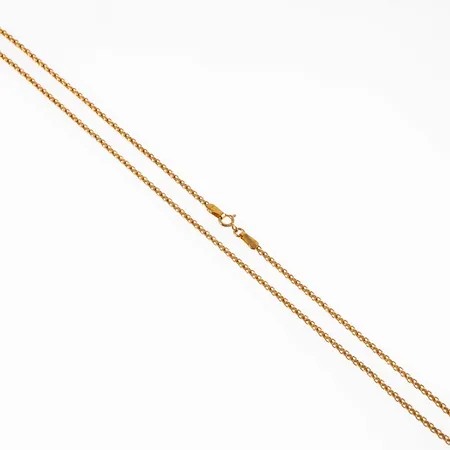 Kedja, tunn x-länk i 21K guld. Den är 40 cm lång, 1,5 mm bred och väger 3,0g. Springring.