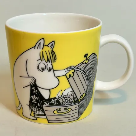 Mugg Mumin från Arabia Snorkfröken gul 2001-2012, höjd 8 cm Ø8,5cm, rymmer 0,3l, små mörka fläckar på flera ställen