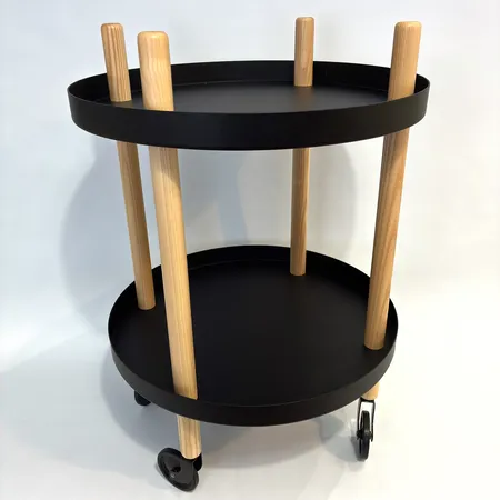 Brickbord från Normann Copenhagen, med hjul, mattlackerade svarta brickor med ben av ask, Ø45cm, höjd 64cm, bruksslitage Skickas med postpaket.