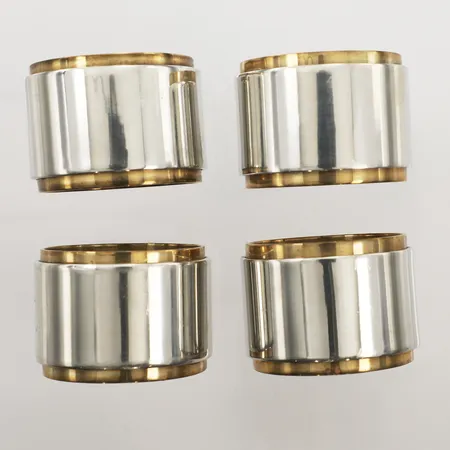 Fyra servettringar, formgivna av Sebastian Schildt för Firma Svenskt Tenn, 2016, tenn och mässing, ca Ø4cm, bredd ca 3cm, samtliga med tygpåse, repor, missfärgad mässing, behov av puts.