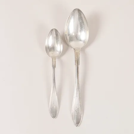 Två skedar, modell Svensk Spets, år 1916, längd: 146 mm samt 190 mm, monogramgravyr, slitage, 830/1000 silver. Vikt: 65 g