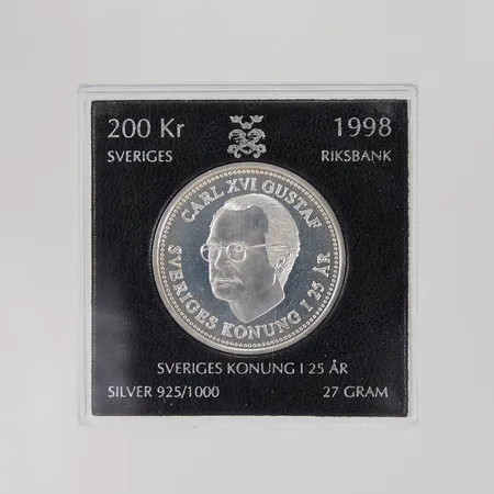 Mynt Sveriges konung i 25år, 1998, nominellt värde: 200kr, plastetui, 925/1000 silver Vikt: 27 g
