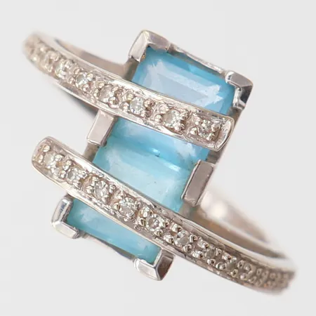 Ring med blåa stenar samt 8/8-slipade diamanter 26x ca 0,05ct, stl: 18, bredd 1,8-13,5mm, vitguld 18K.  Vikt: 6,1 g