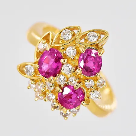 Ring med diamanter ca 0,20ctv, röda stenar, stl 15¾, bredd ovandel 15mm, liten nagg på en röd sten, 18K Vikt: 4,6 g