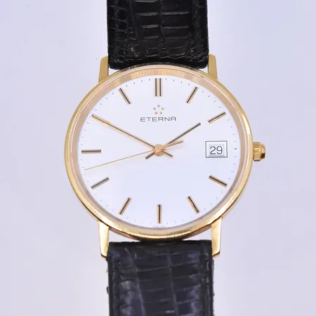 Herrur Eterna, quartz, datum, Ø34 mm, graverad boett, svart läderband, 18K. Bruttovikt 27g.