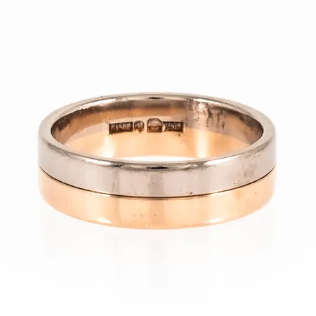 Slät ring i 18K röd- och vitguld. Den är i storlek 18¼, är 6 mm bred, 1,5 mm hög och väger 7,9g. Stämplad JML, 18K & kattfot. Fint skick - ingen gravyr.