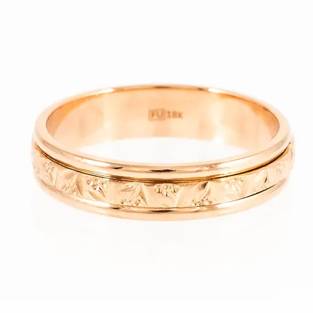 Mönstrad ring i 18K guld. Den är 5,3 mm bred, är i storlek 20¾ och väger 7,0g. Stämplad FU 18K. Fint skick - ingen gravyr.