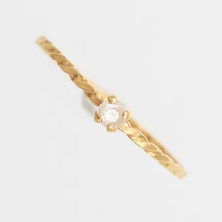 Ring tvinnad med vit sten, stl: 16, bredd 1-2,7mm, skev, 18K.  Vikt: 0,4 g