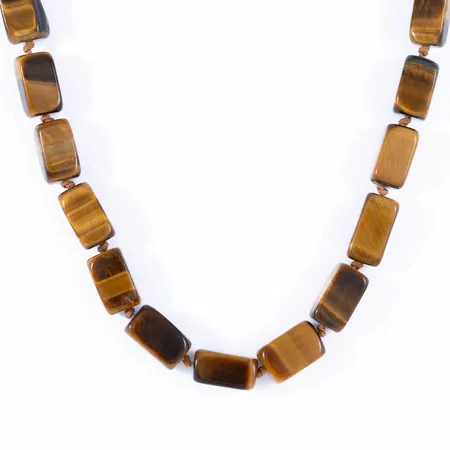 Stencollier Tigeröga 49 cm långt, 7 - 8 mm brett. Fint lås i silver med cabochonslipad tigeröga. Uppträtt på gulbrun nylontråd. Vikt: 60,4g. 