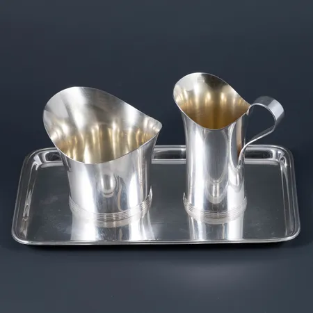 En gräddkanna höjd c:a 8,5 cm. En sockerskål höjd c:a 6 cm. Ett fat c:a 17,5 - 10,5 cm i silver. Total vikt: 219,6g. Stämplat I9 (1959), GAB (Guldsmedsaktiebolaget i Stockholm), kattfot.