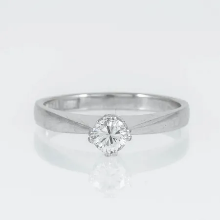 Enstensring i 18K vitguld med 1 x 0,26ct briljantslipad diamant. Den är i storlek 16½, är 2 - 5 mm bred och väger 3,2g. Stenstorlek 0,26ct ingraverad. Stämplad B10 (1976), ÖRN (Örns Juvelatelje, Göteborg), 18K, kattfot. 