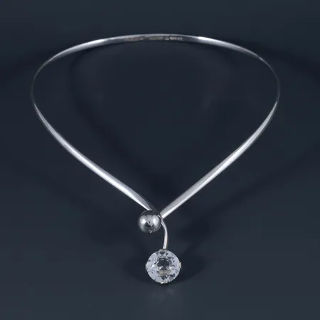 Stelt collier i silver med Bergkristall Ø 15 mm. Innermått c:a 39 cm, 4 mm brett och väger 36,3g. Öppningsbar fram. Stämplad S9 (1968), Pege ALTON, Falköping. 
