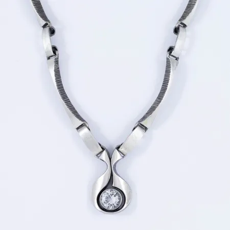 Collier i silver (925/1000) Karl Laine för Finnfeelings Finland: Integrerat hänge med bergkristall. Det är 41 cm långt, 2 - 5 mm brett. Hängets mått 22,5 x 14,5 mm. Vikt 20,9g. Fint skick. 