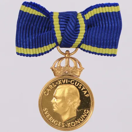 Medalj Carl XVI Gustaf Sveriges konung - För nit och redlighet i rikets tjänst, längd 27mm inklusive ögla, bredd 15mm, personlig gravyr, krona och ögla i 18K, mynt 23K Vikt: 5 g