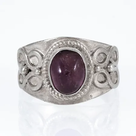 Ring i silver (925/1000) med en cabochonslipad Ametist. Den är i storlek 18¾, är 4 - 13,5 mm bred och väger 4,7g.