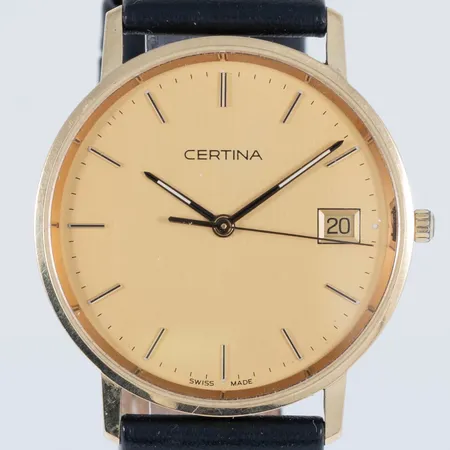 Herrur Certina i 14K guld med svart läderband. Boett Ø 33,5 mm, datumvisare, safirglas, quartz, gravyr. Bruttovikt: 26,3g. Går ej - Batteribyte krävs?