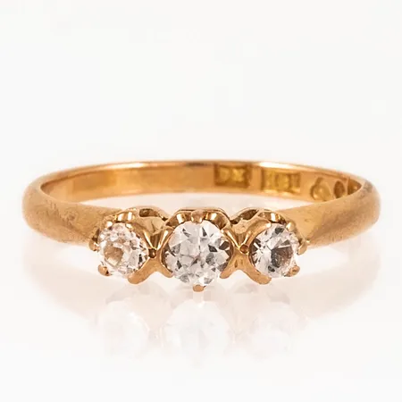 Ring i 18K guld med tre vita stenar (nötta). Den är 1,7 - 3,9 mm bred, är i storlek 15½ och väger 2,3g. 