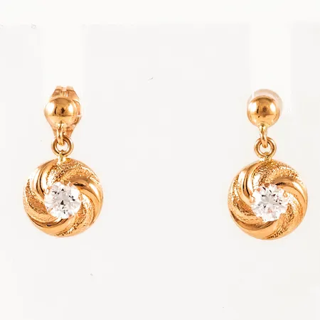 Hängande örhängen i 18K guld med vita stenar (cz). De är 3,5 - 8,5 mm breda, 15,5 mm långa och väger 1,1g. Ena snurrebussen saknas, men ny i plast medföljer. 