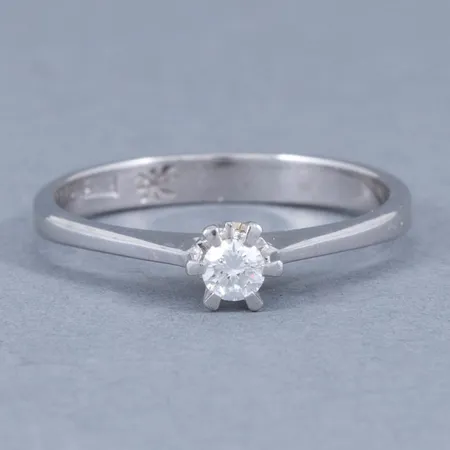 Stjärnring Galaxia i vitt guld 18K med en briljant 0,10ct (TW-Luppren/vvs). Den är 2,5 - 4,2 mm bred, är i storlek 16 och väger 2,0g. Stjärnringen stjärna, 18K & svensk importstämpel. Nypris idag ca 16.500kr.