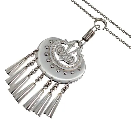 Collier KALEVALA KORU FINLAND, "Kuutar" (mångudinnan), silver 925/1000, design Germund Paaer (1881-1950), tillverkad 1982, integrerat hänge, total längd inkl. översta öglan 10,5 cm, bredd 50 mm, kedja Ankarlänk, ej öppningsbar, längd 71 cm, bredd 2,5 mm, förefaller sparsamt använd Vikt: 29,4 g