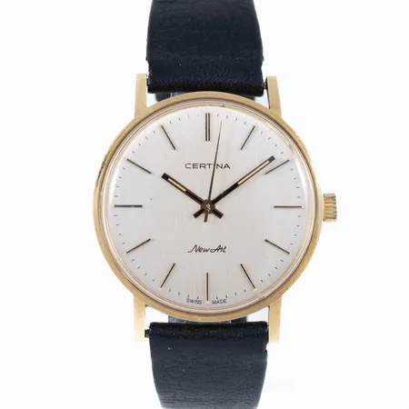 Herrur Certina New Art i 18K guld med nött läderband. Boett Ø 33,5 mm med gravyr "För nit....". Repigt plastglas. Manuellt urverk.