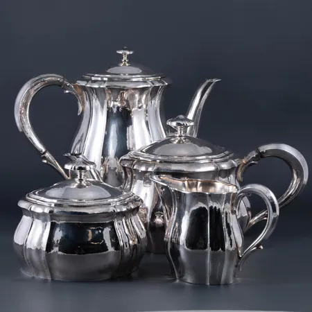 Kaffekanna (ca 19,5 cm hög), tekanna (ca 12 cm), sockerskål (ca 11 cm) och gräddkanna (ca 9 cm) i silver (830/1000). Stämplade E.H.K. 830 / GRL (G Lindbäck, Nederkalix), svensk importstämpel, S, T7 (1921). Bruksskick.  "Värmeavskiljarna" saknas på båda kannornas handtag. Total vikt 1535g. Skickas med postpaket.