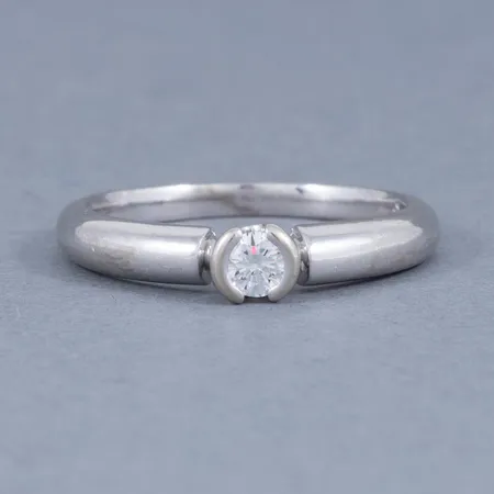 Stjärnring Dione i vitt guld 18K med en briljant 0,18ct (TW-vs). Den är 2 - 4,4 mm bred, är i storlek 18 och väger 4,3g. Stämplad HS, kattfot, 18K, Stjärnringens stjärna. Stenstorleken ingraverad. Nypris idag ca 24.600kr.