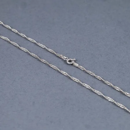 Kedja singapore i silver (925/1000). Den är 50 cm lång, 1,8 mm bred och väger 2,8g. Springring.