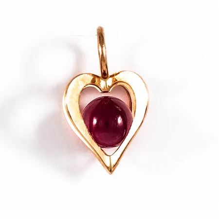 Hänge i 18K guld med en röd kula (julis månadssten). Det är 14,7 mm långt inkl. fast ögla och väger 0,7g.