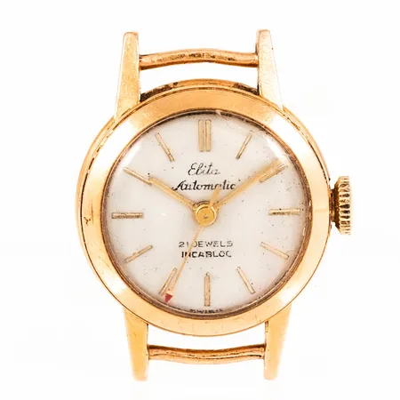 Smyckeur Elita i 18K guld utan band. Boett Ø 19 mm. Automat. Skadat plastglas. Bruttovikt 11,5g.