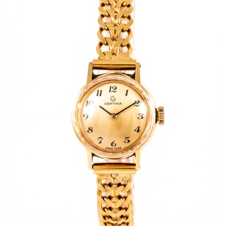 Damur Certina i 18K guld med 18K band. Boett Ø 22 mm. Safirglas. Manuellt urverk. Totallängd 18 cm. Det matterade bandet är 9,4 mm brett och har kistlås. Vikt 35,0g. 